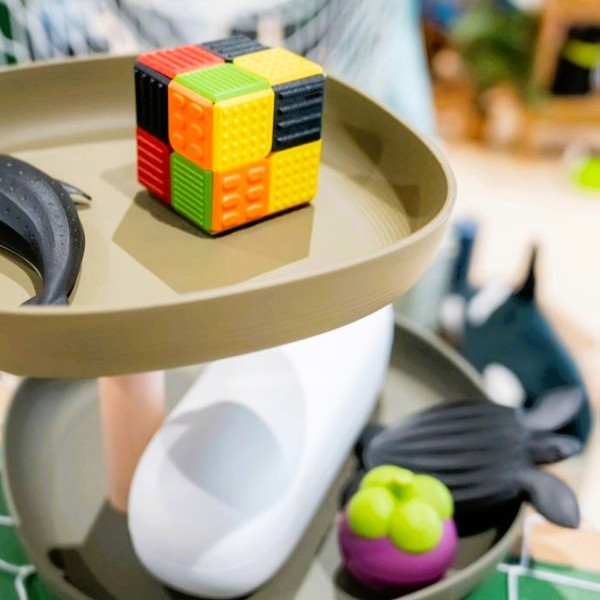 A display with an array of toys and a cube made from plastic discards (PP, PET and PE).