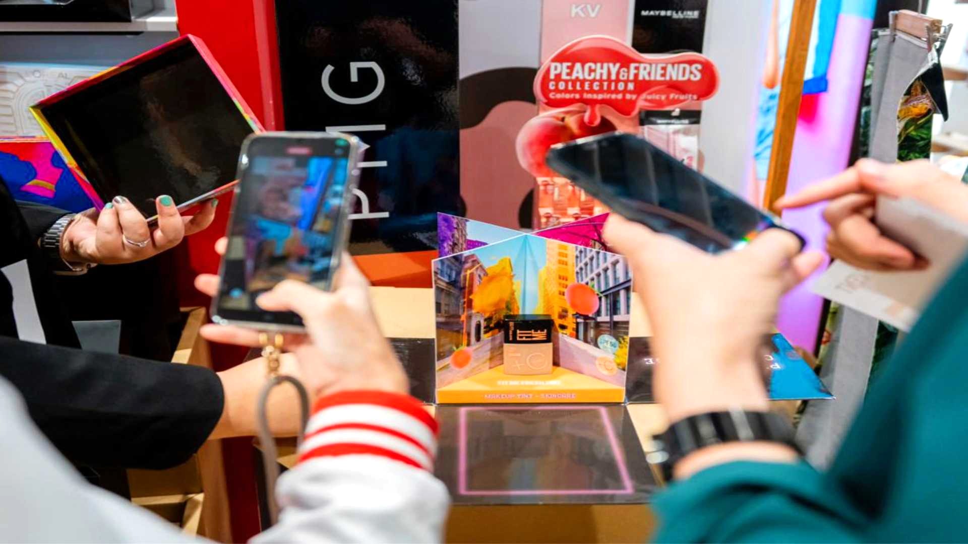 Several individuals browsing a product showcase and taking photos with their mobile phones.