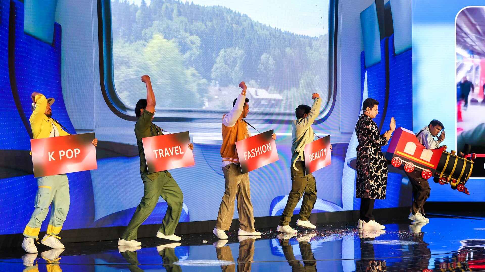 YouTube-Brandcast-2024-India-PMG-5.jpg Performers on stage, joyfully lifting their arms, carrying red-coloured signs that say K-pop, Travel, Fashion and Beauty, creating an energetic atmosphere.