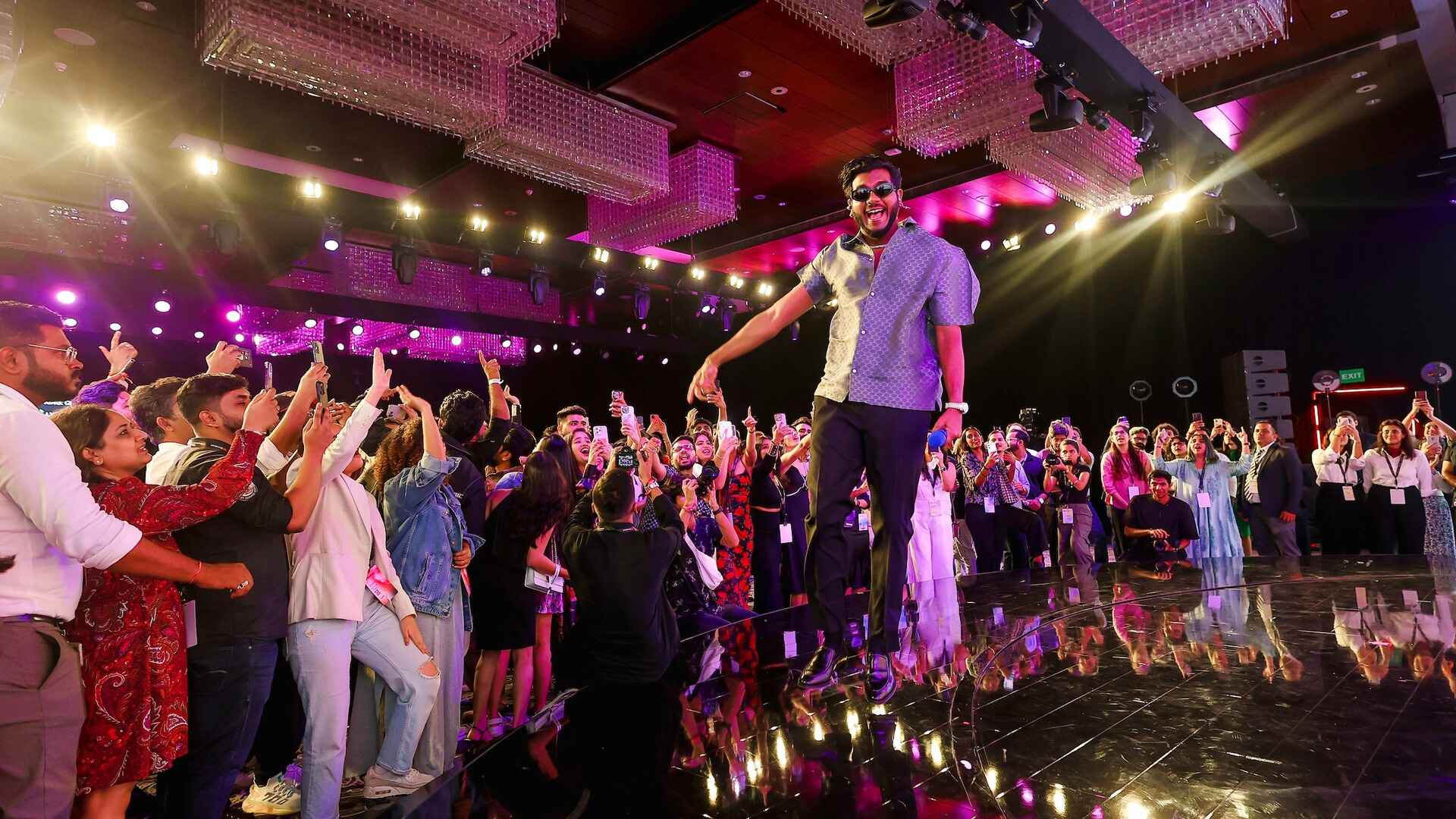 YouTube-Brandcast-2024-India-PMG-6.jpg A singer jumps on stage, surrounded by an enthusiastic crowd of YouTube Brandcast 2024 India attendees.